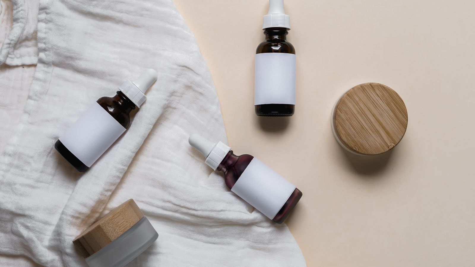 Labelled glass skincare bottles lined up for comparing body care ingredients