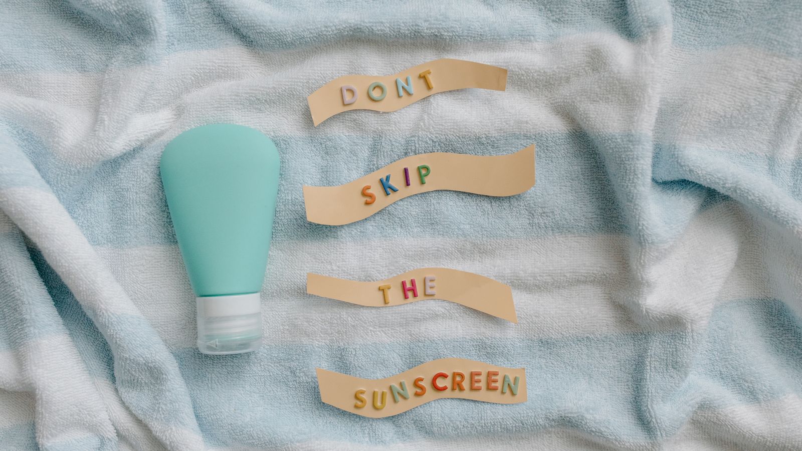 Ceramide sunscreen bottle on a towel with a reminder not to skip sun protection