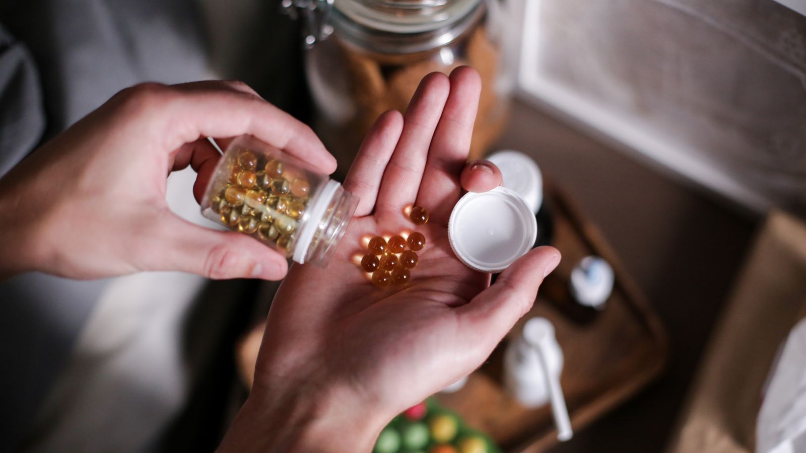 Hands holding supplement capsules, the honest question of do hair supplements work