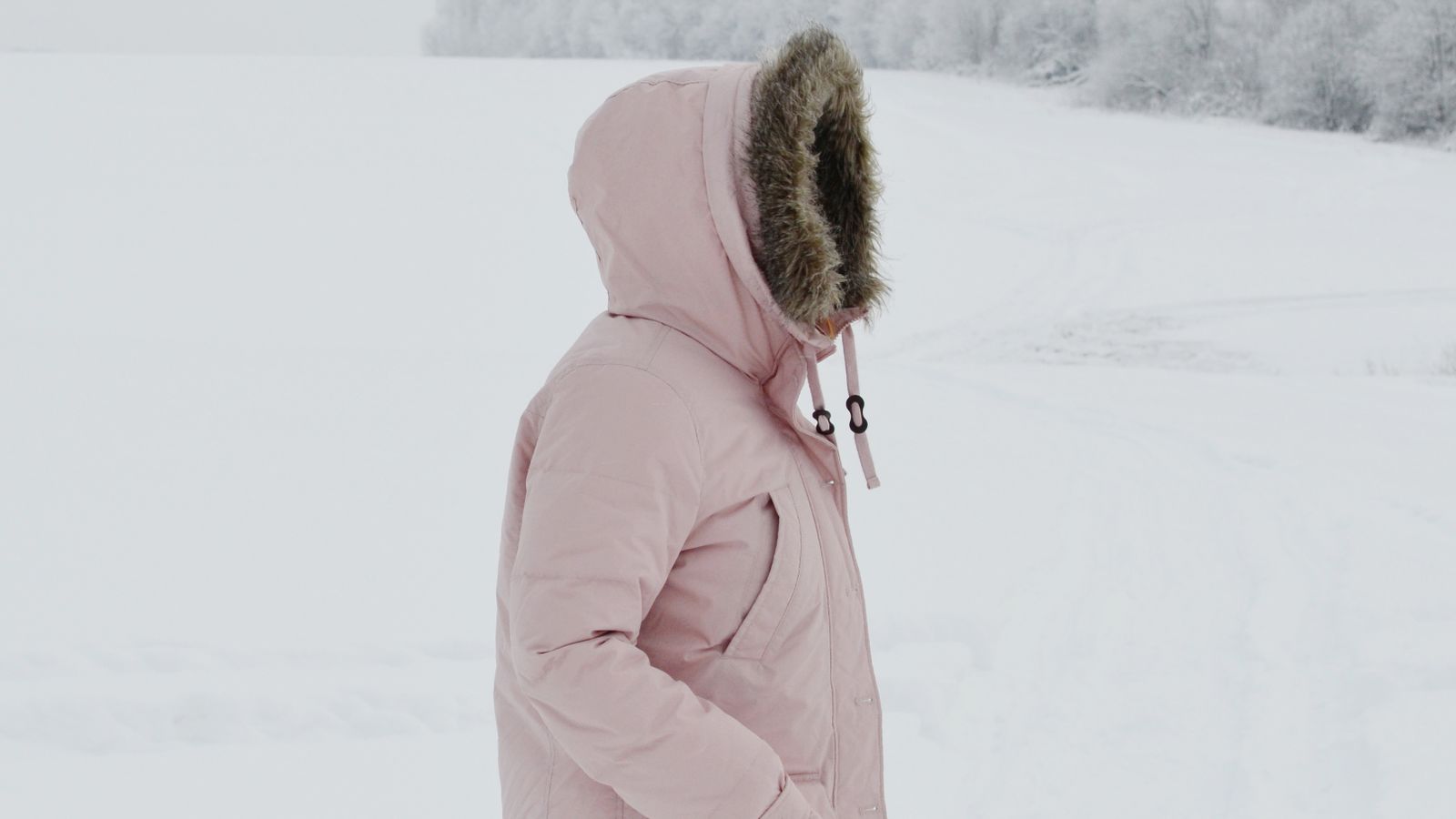 Woman in a winter coat outdoors in the cold, the weather behind dry scalp in winter