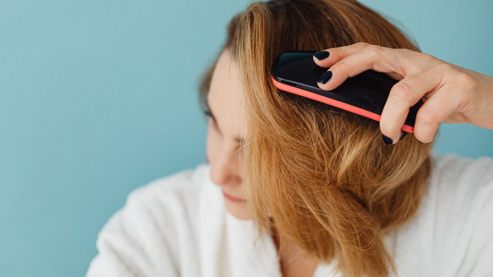 Woman brushing her hair while noticing estradiol hair effects on texture and density