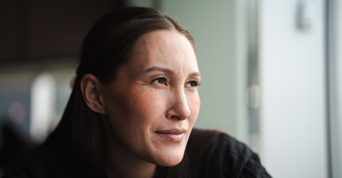 Contemplative woman in soft natural light indoors, reflecting questions about gluten and mental health