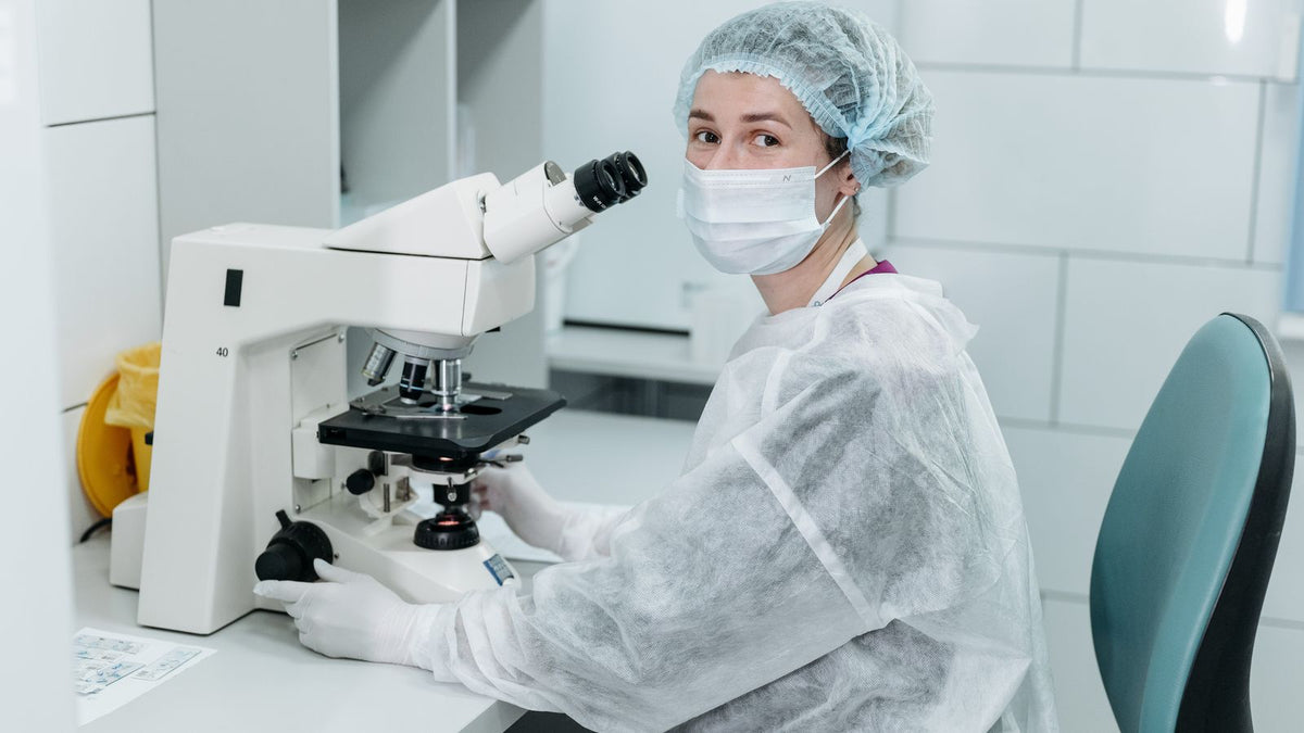 Scientist using a microscope to study hair follicle stem cells in a laboratory