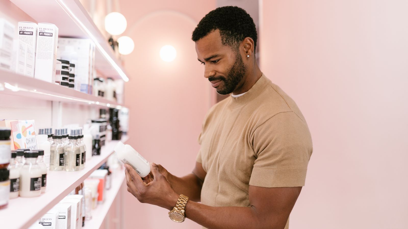 Man comparing bottles on a shop shelf while choosing between hair growth products for men and women