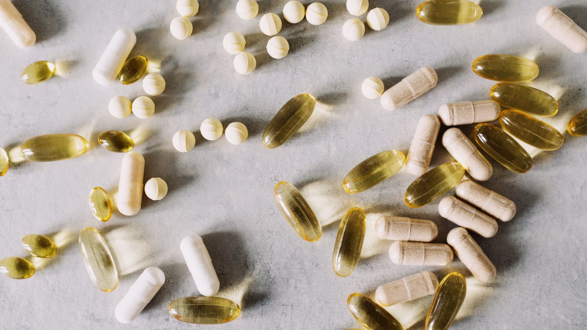 Assorted vitamins and supplements on marble, the products sold as hair nutraceuticals