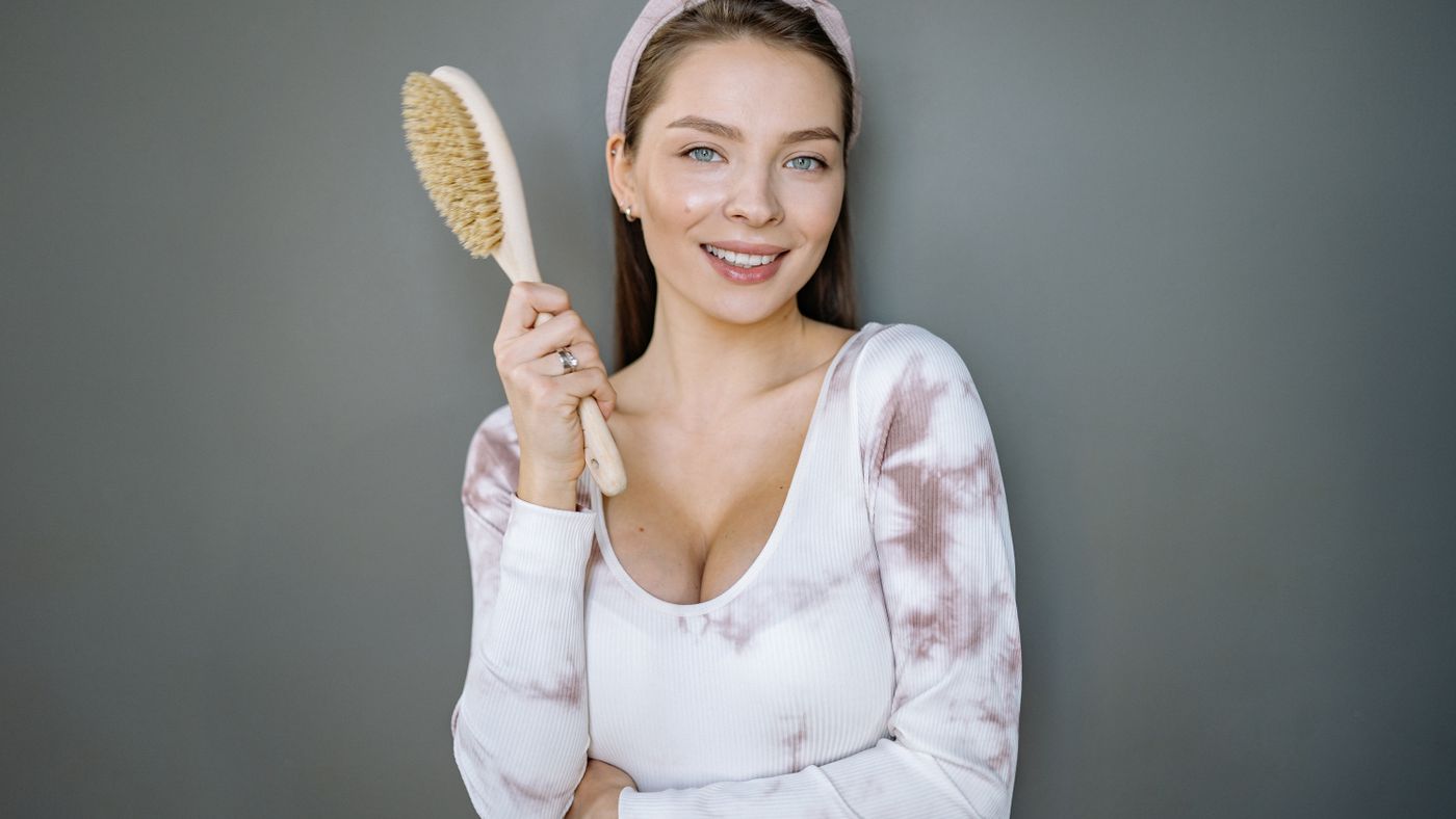 Smiling woman with long hair holding a brush, setting realistic expectations for hair regrowth treatments