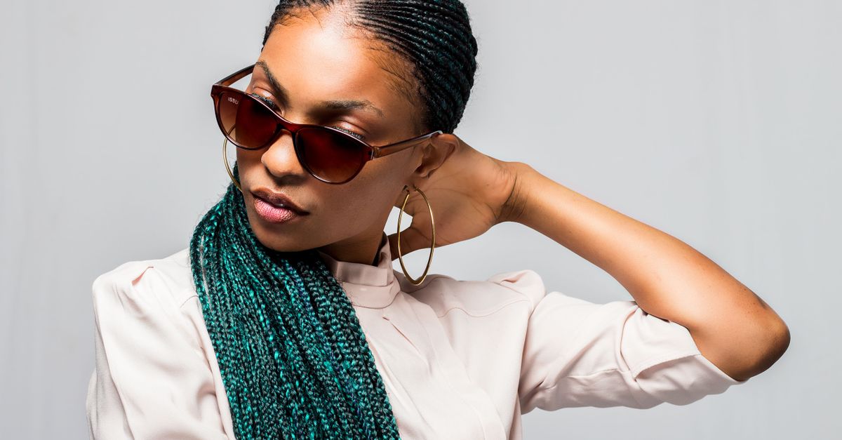 A woman wearing braids swept away from her face, the styling choice that hairline preservation depends on
