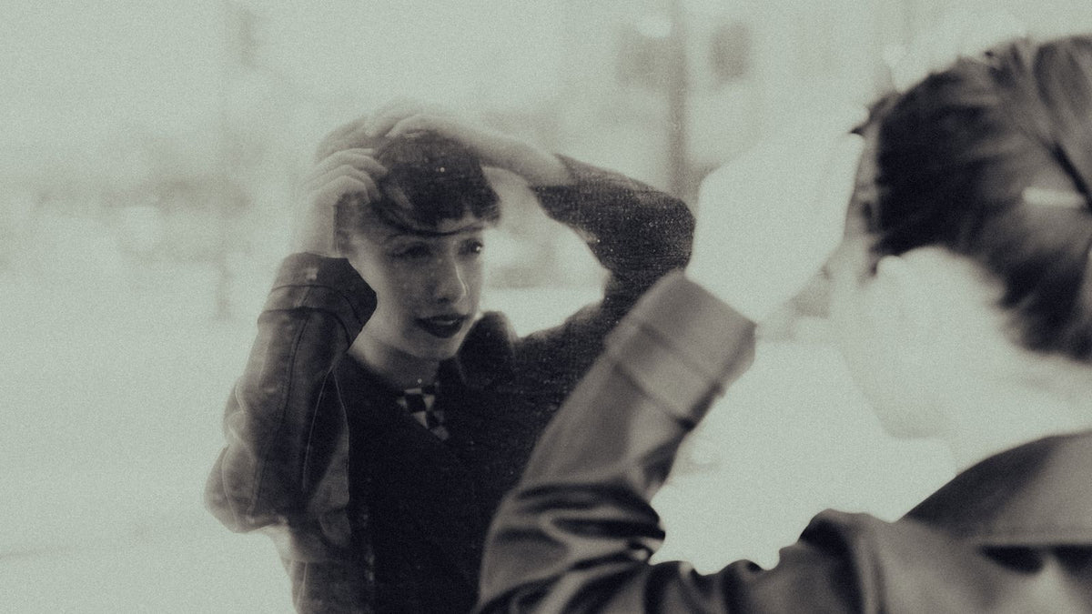 A woman fixing her hair by a window, the everyday moment when hormone therapy hair loss is usually first noticed