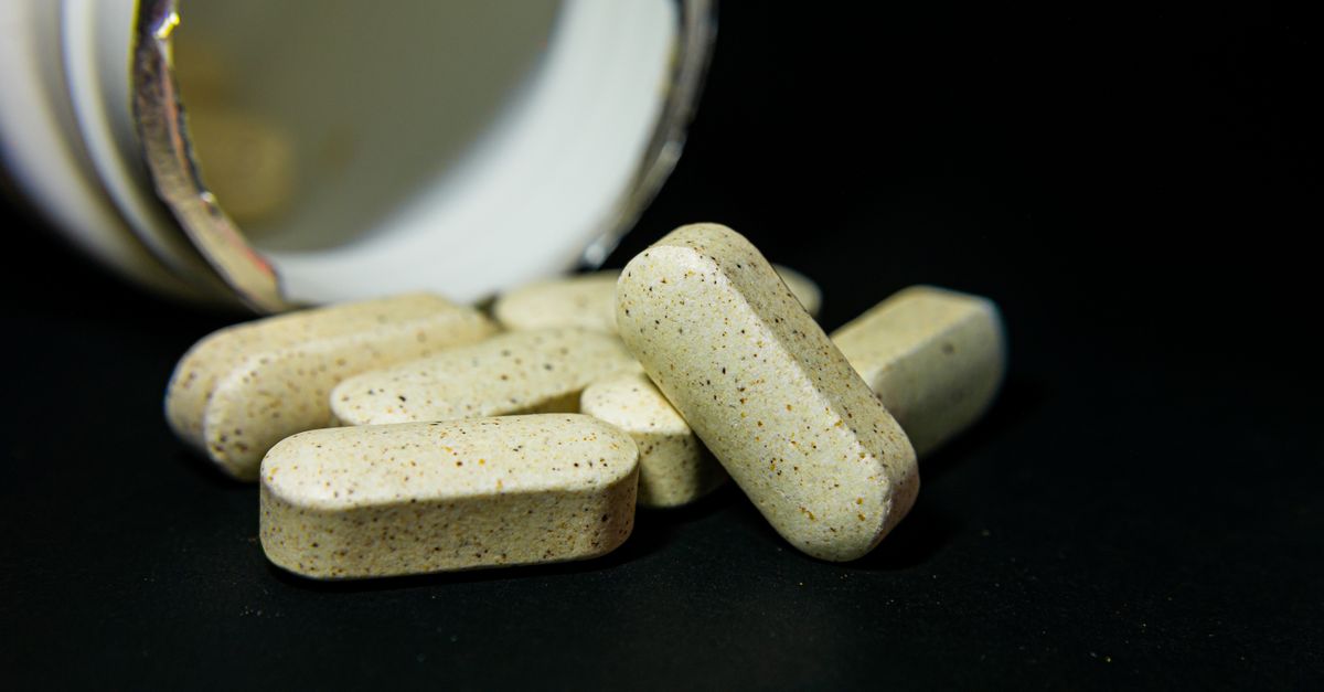 How much biotin for hair, shown as supplement capsules spilled from a bottle