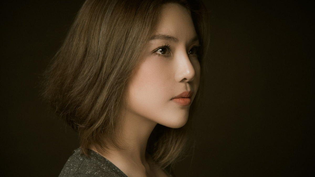 Side profile of a woman with a deep side parting, part of how to hide thinning hair front woman styling