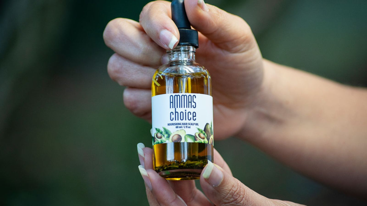 Hands holding a bottle of the best hair oil for their hair type