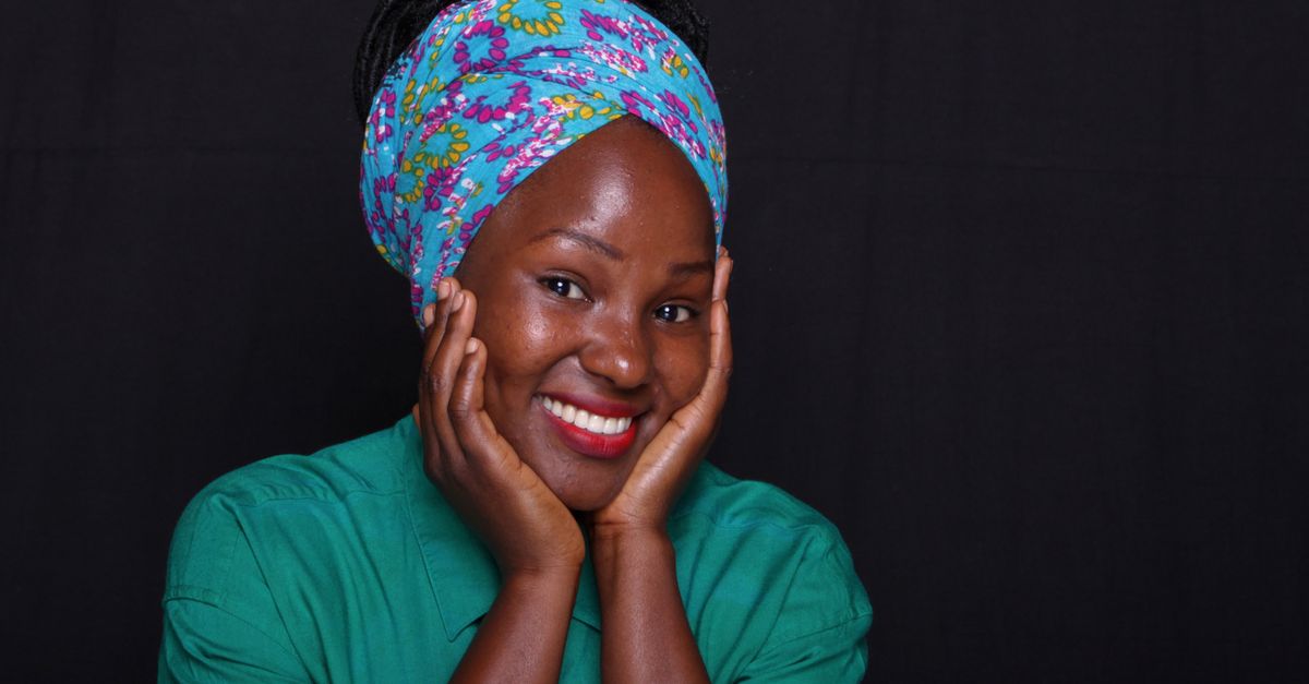 Smiling woman in a floral head wrap showing how to wear a headband to cover hair loss