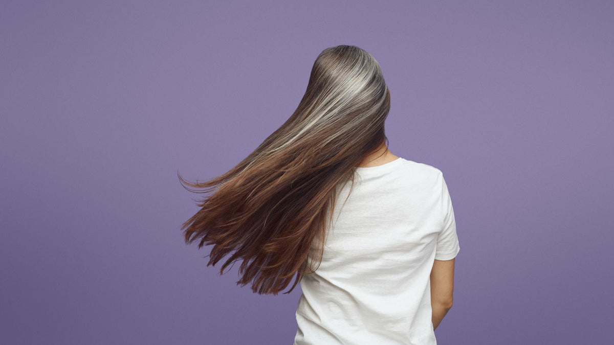 Woman with long flowing grey hair showing hrt hair thickness and natural fullness