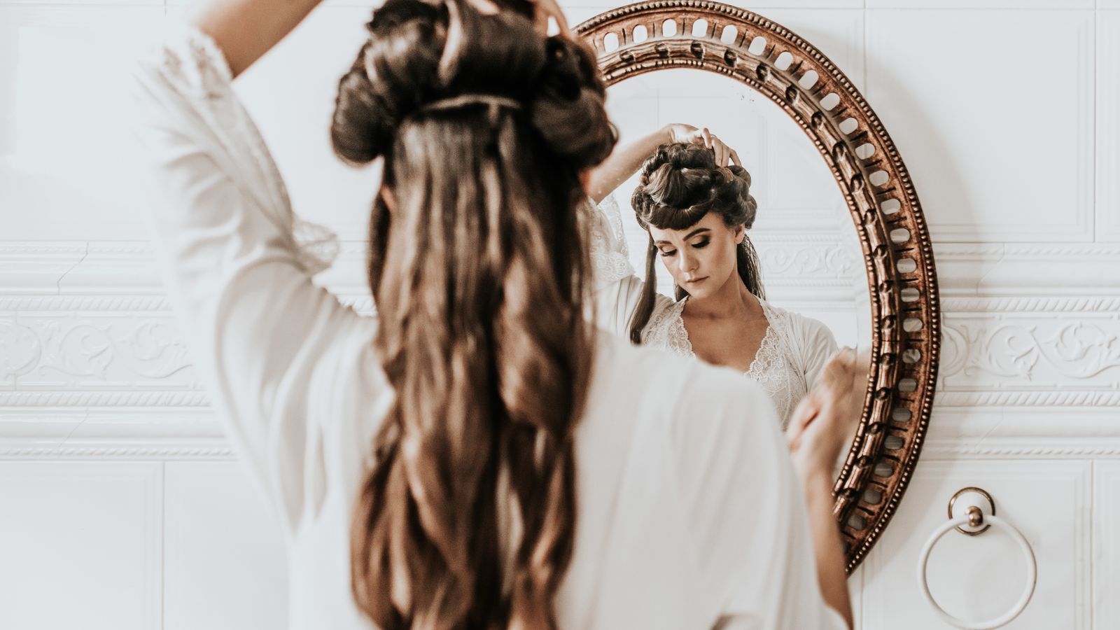 Woman checking her hair in the mirror against the Ludwig scale for female hair loss