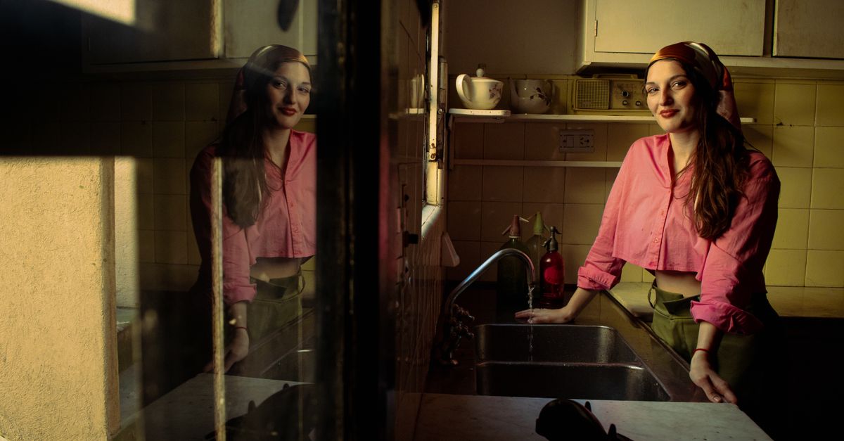 Woman in midlife checking her hairline in a mirror, illustrating menopausal hair thinning