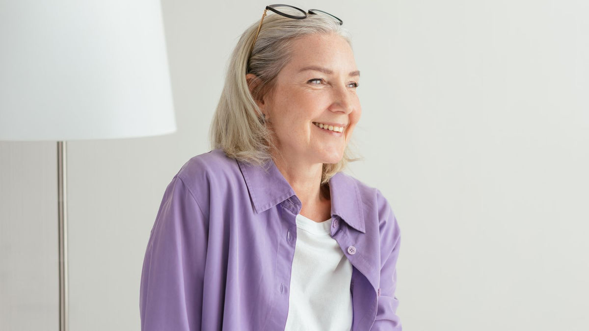 Smiling woman with grey hair, living well through menopause hair loss