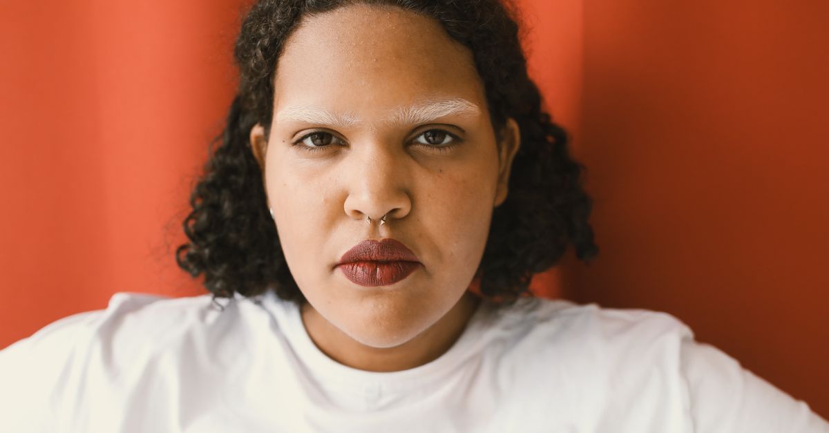 Portrait of a woman with full curly hair, illustrating a guide to MTF hair loss