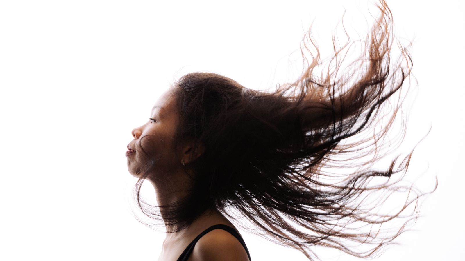 Woman with strong healthy flowing hair using a natural hair strengthener