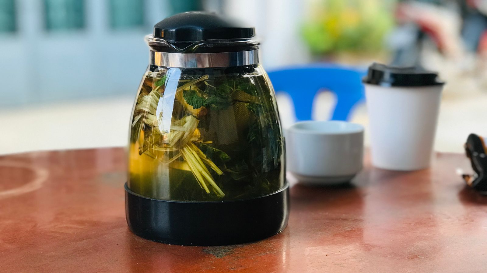 Glass teapot of fresh herbal nettle tea with green leaves