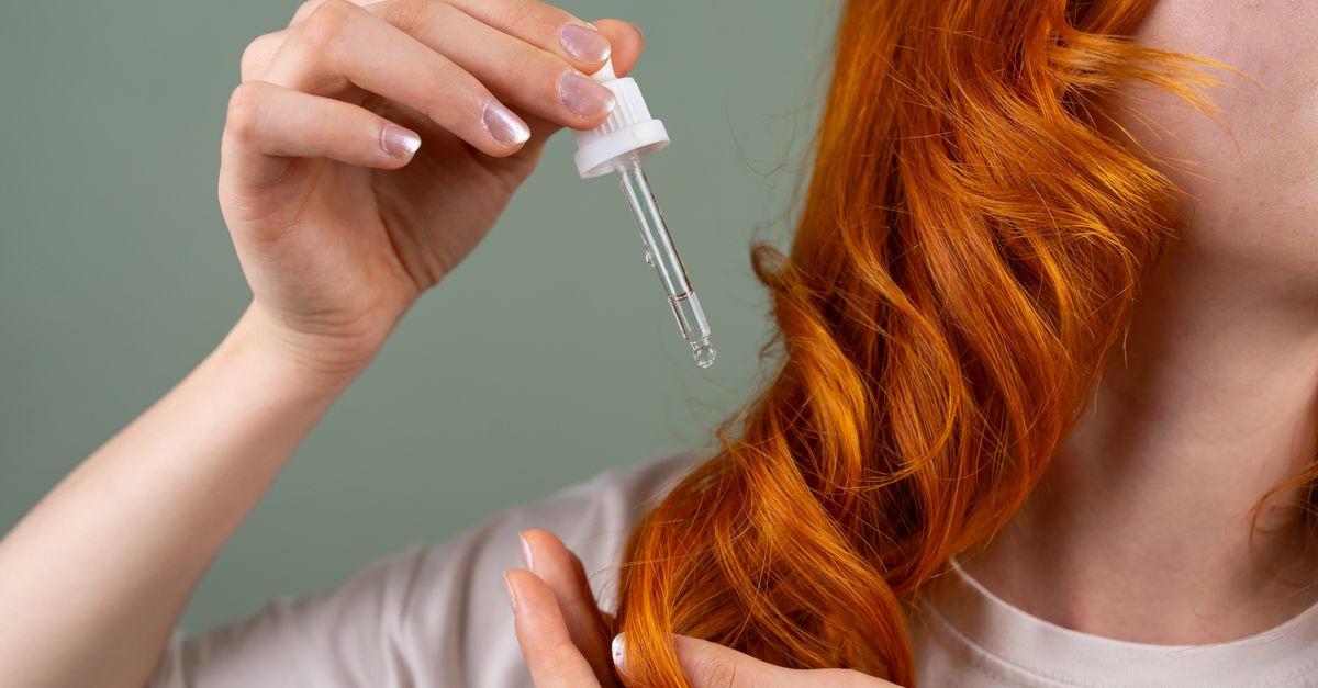 Applying lightweight marula hair oil with a dropper