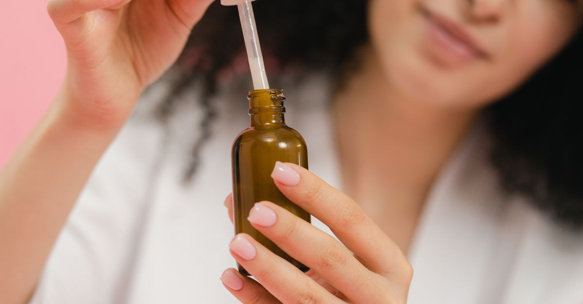 Woman using a dropper skin care product after a course of skin medication