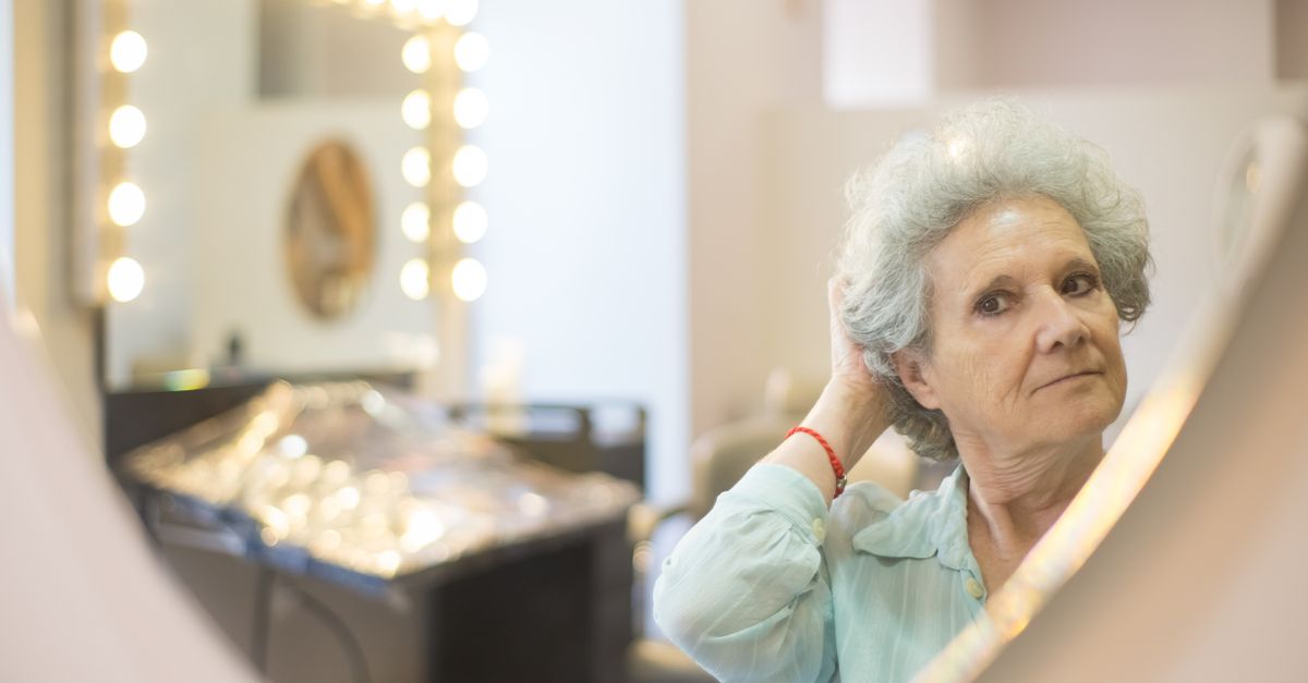 Woman noticing post HRT shedding while checking her hair