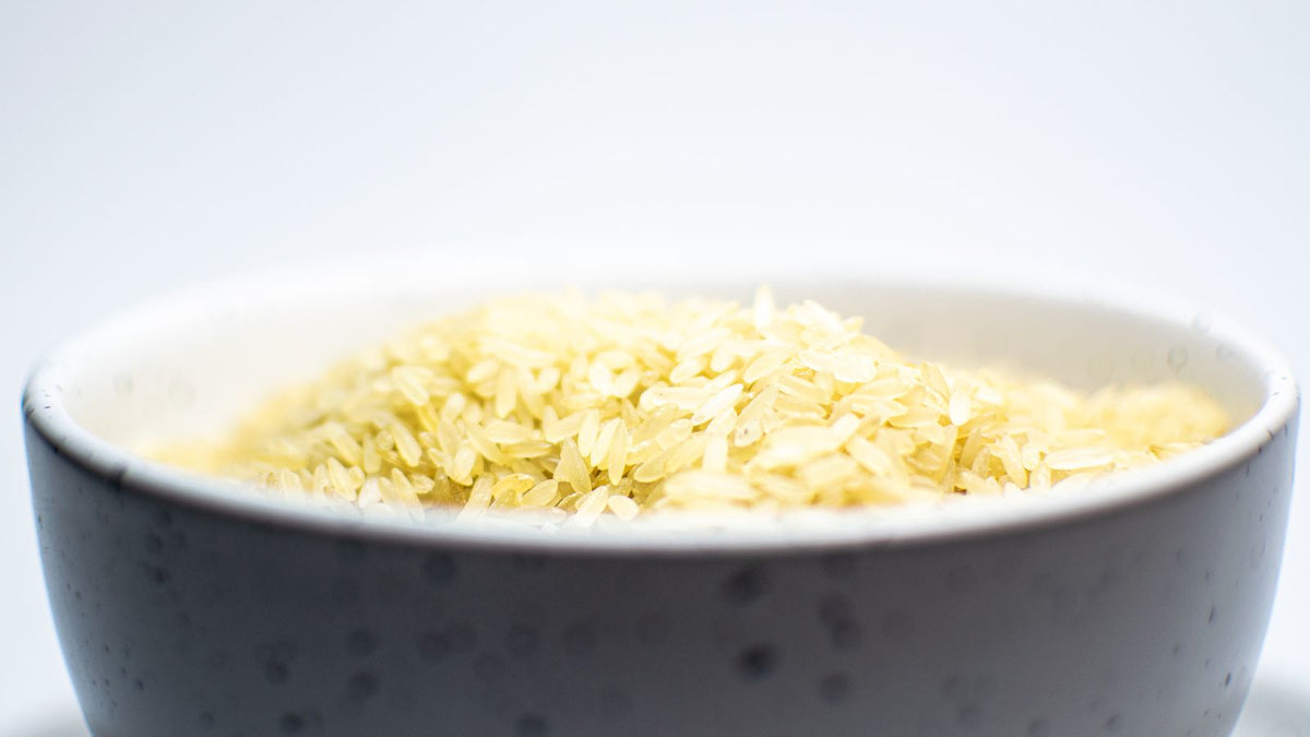 Uncooked white rice in a bowl, the starting point for rice oil vs rice water for hair