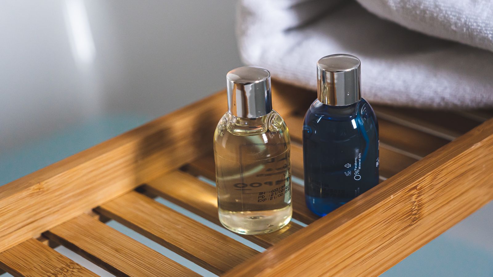 Shampoo and conditioner bottles paired on a bamboo tray