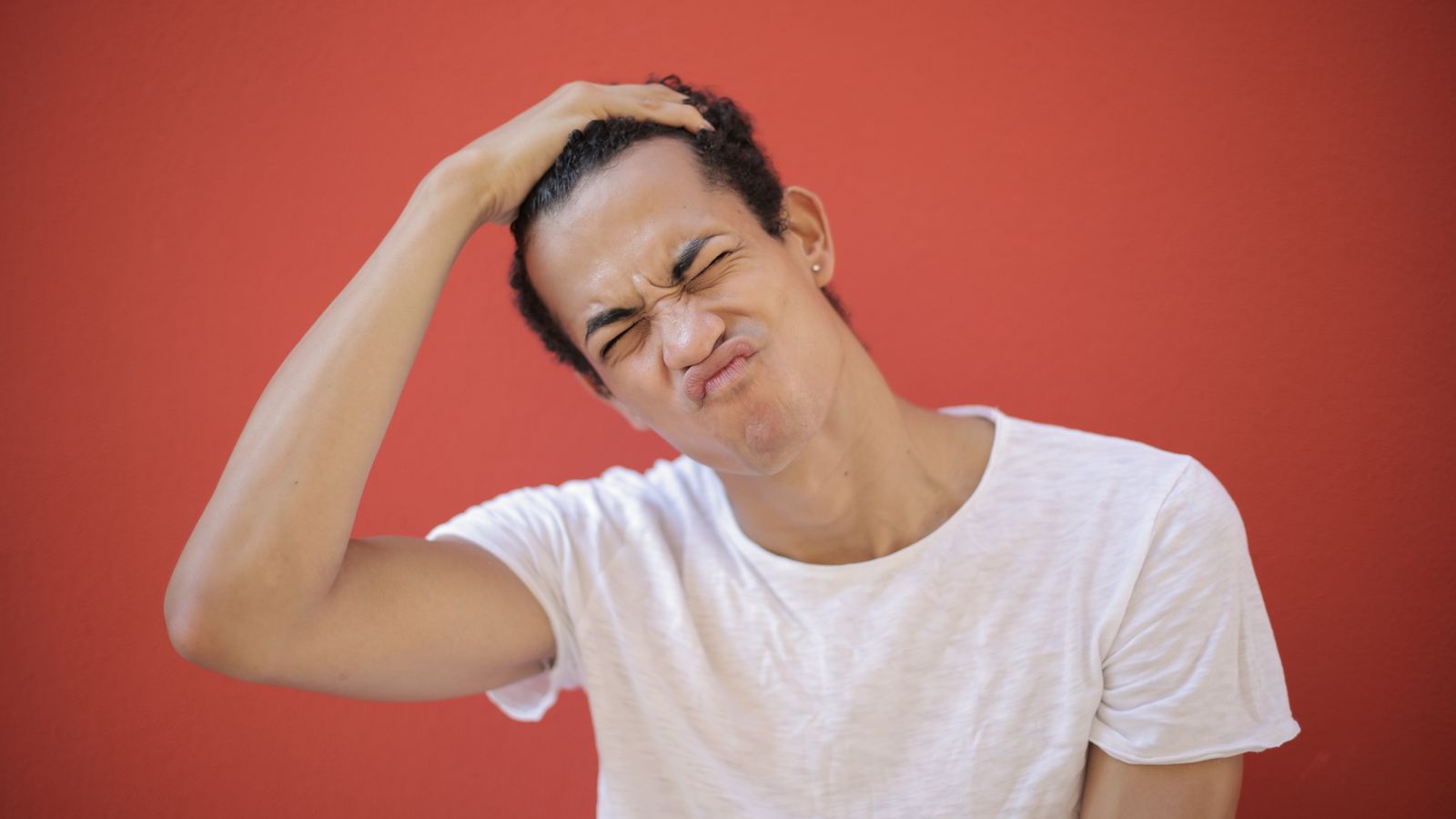 Woman with her hand on her head, the frustration of a smelly scalp that will not clear