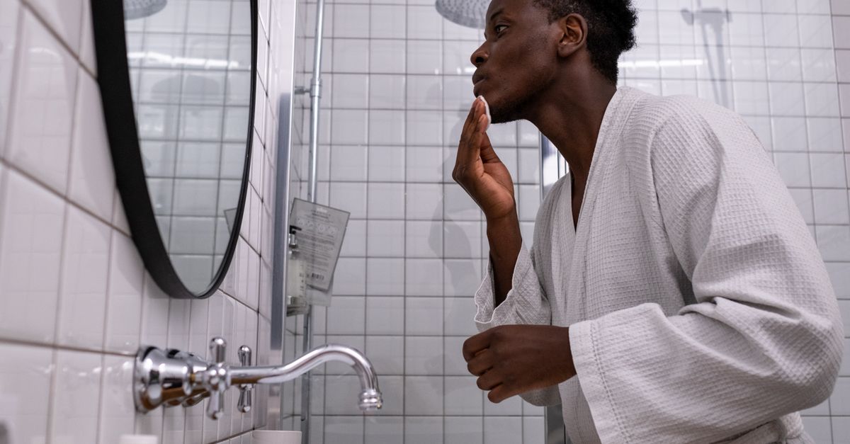 Man checking his hairline in the bathroom mirror after noticing testosterone hair loss