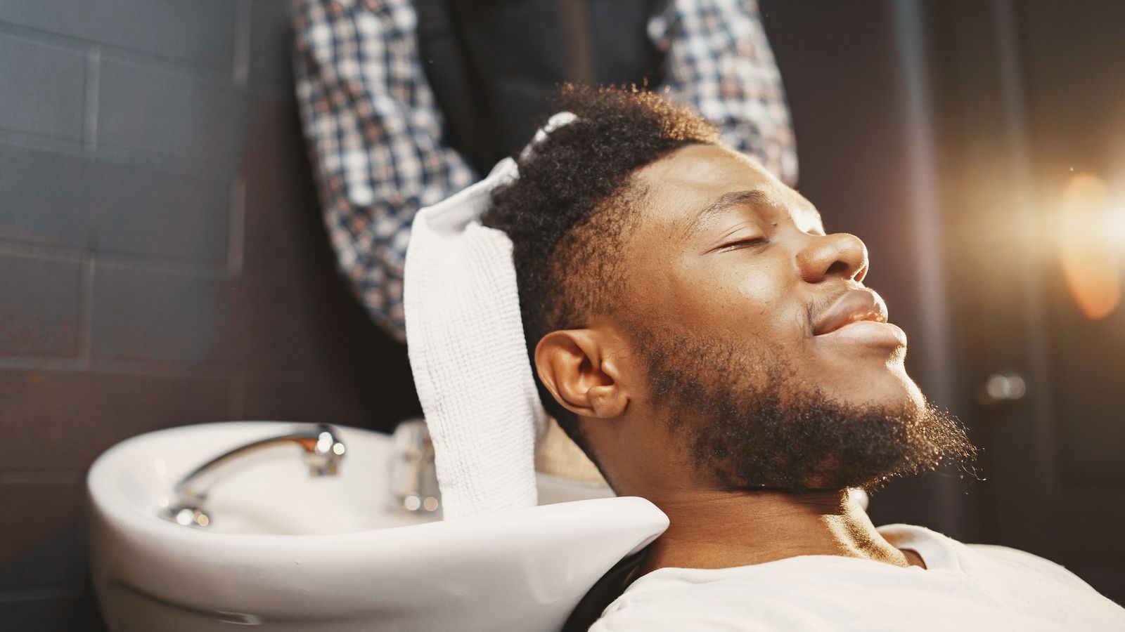 Man having hair washed with thickening shampoo