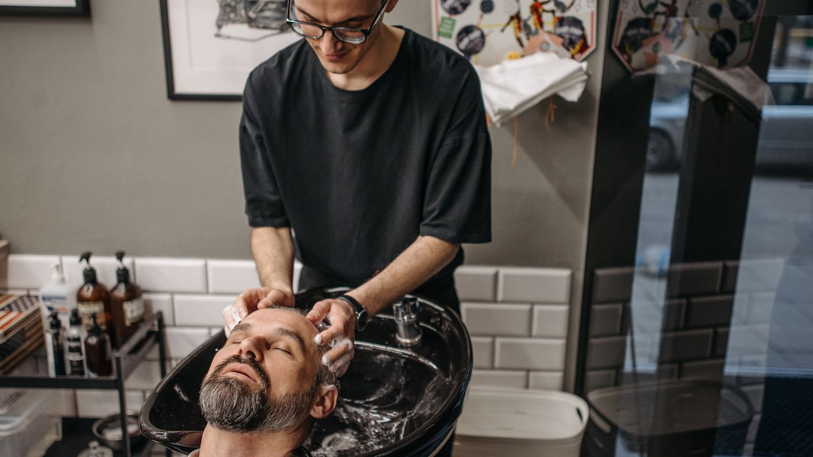 Client having hair washed at a salon basin with a thickening shampoo men can use daily