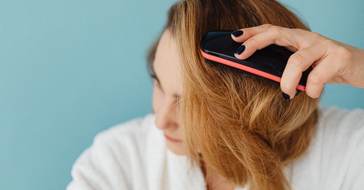 A woman brushing her hair, a daily moment when thinning hair in women is first noticed