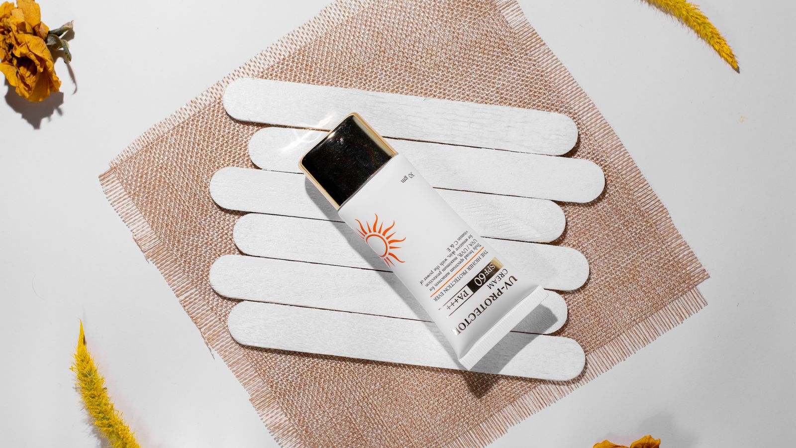 A flat lay of sun protection next to natural elements, illustrating how to choose a tinted sunscreen