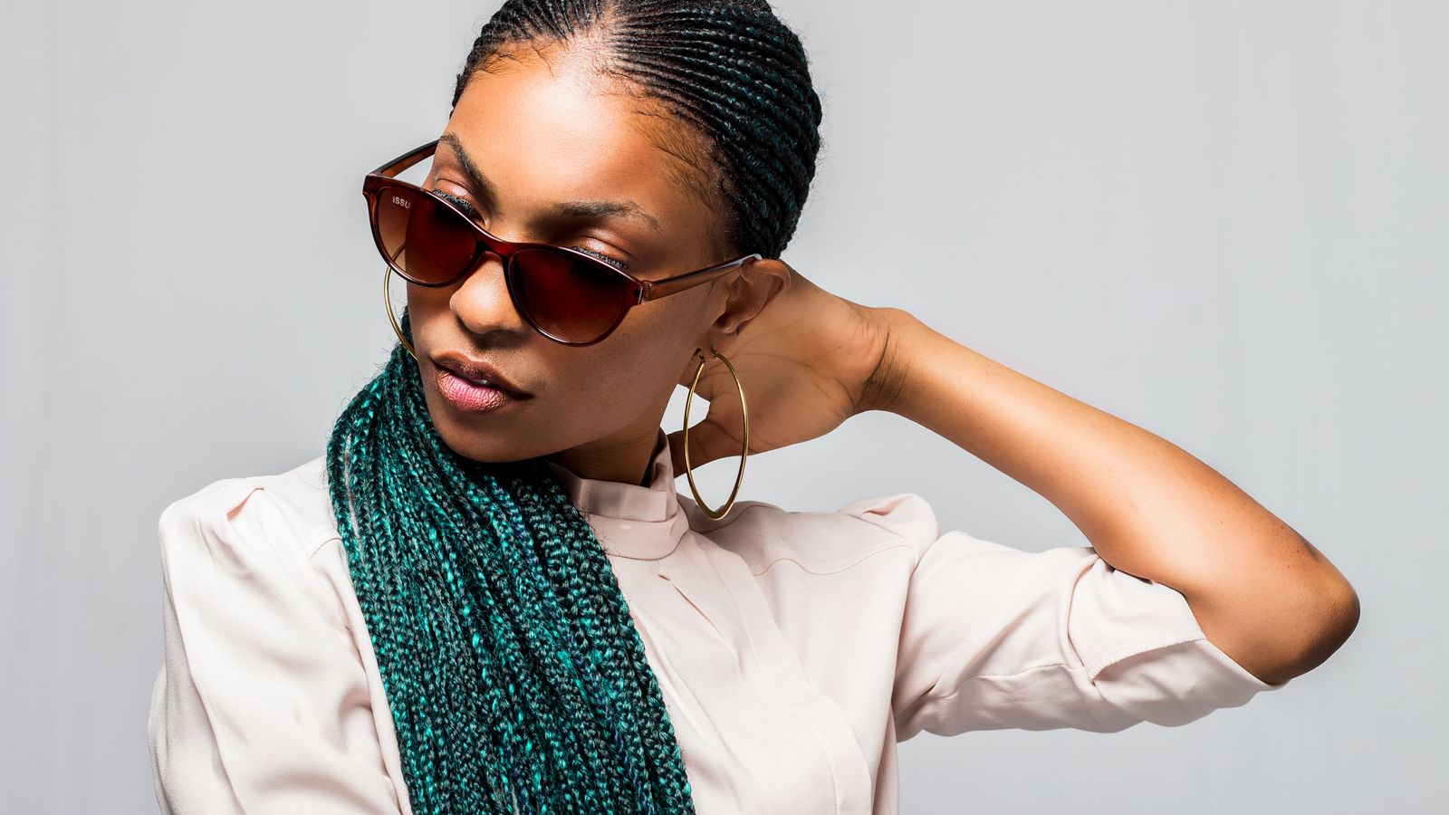 Portrait of a woman with long braids, the styles most associated with traction alopecia