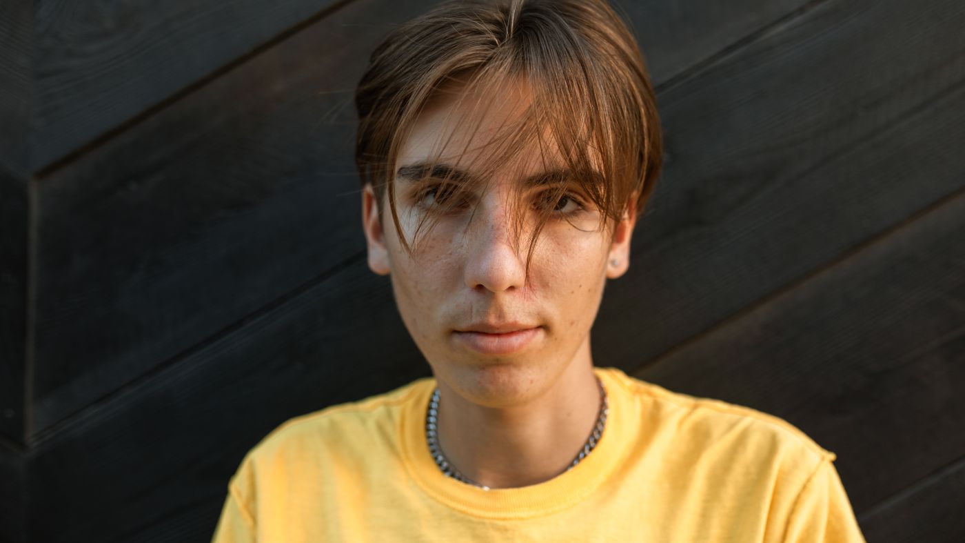Transgender hair care: person with a fresh style standing confidently outdoors