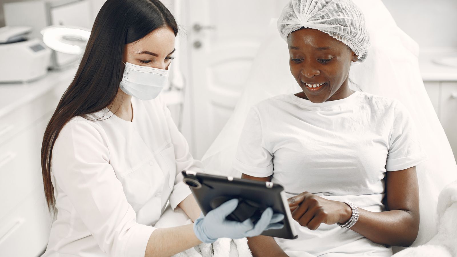 Patient and clinician reviewing results on a tablet, the consultation a trichologist in Altrincham gives before any treatment