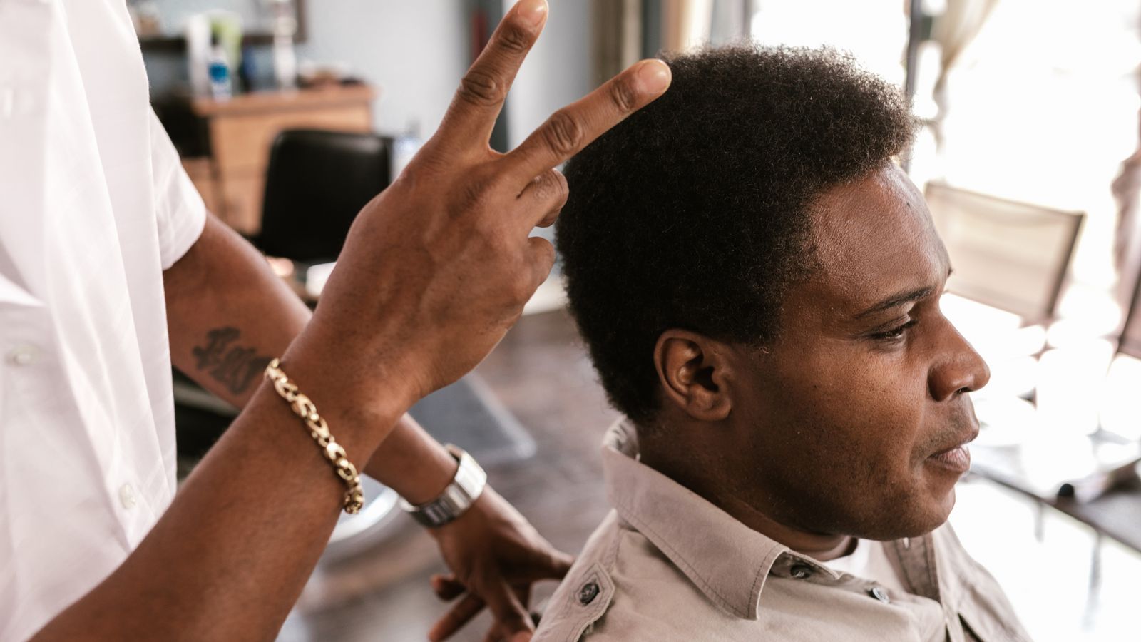 Barber styling a client with afro textured hair, reflecting the mix of hair types a trichologist in Barking sees