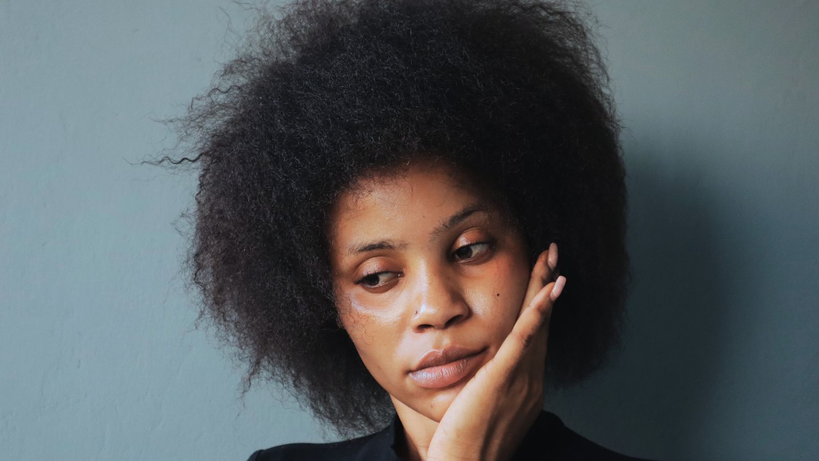 Black woman with natural afro hair, the kind of hair a trichologist in Brent sees most often