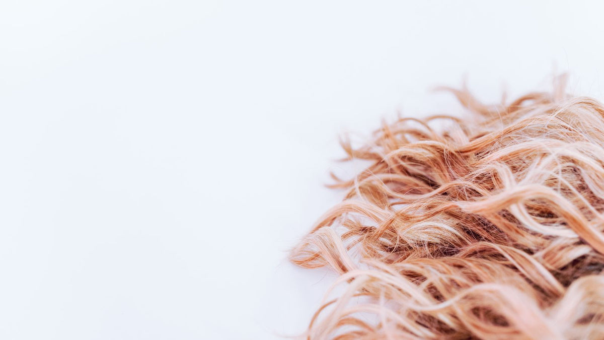 Close-up of wavy strawberry blonde hair lengths, the kind of sudden texture change people ask a trichologist in Darlington about