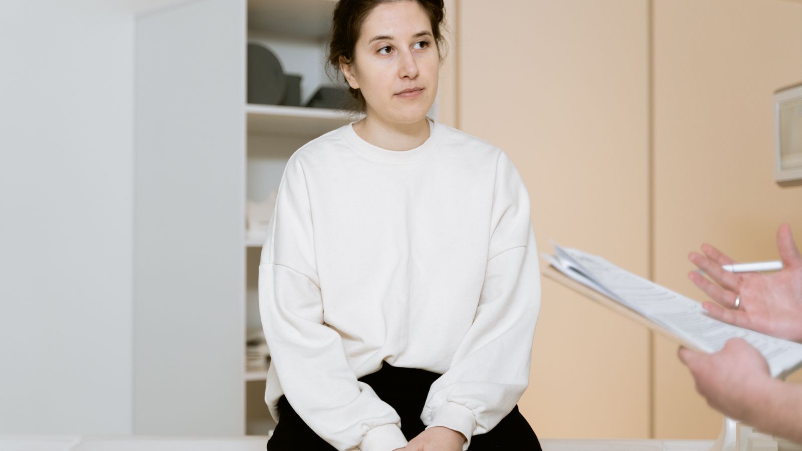 Woman sitting in a bright clinic during a consultation with a trichologist in Richmond about hair and scalp concerns