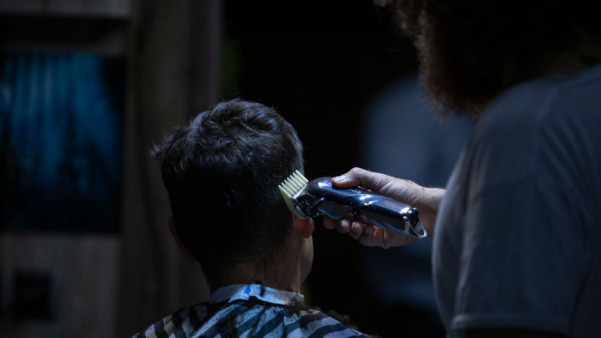 Barber using electric clippers for a short, tidy haircut, the kind of cut men ask about before seeing trichologists Basildon