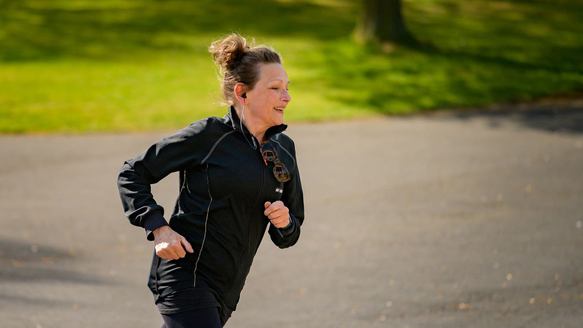 Woman jogging in a sunny park, illustrating a trichologists High Wycombe guide to everyday habits and hair