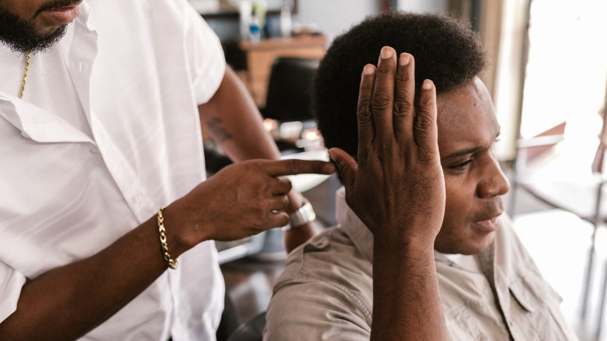Hair professional checking a client's scalp in a salon, a guide to trichologists Londonderry