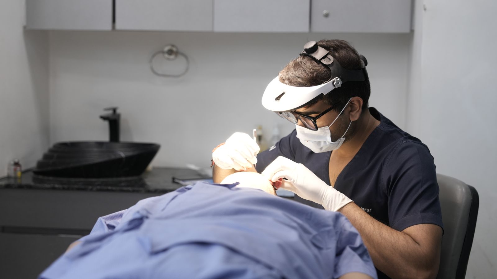 Dermatologist treating a patient in a modern clinic, the medical side of what trichologists in Newtownabbey refer on