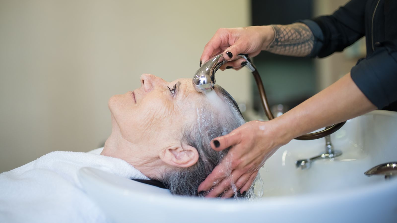 Woman receiving a salon hair wash, trichologists Stockport hair care