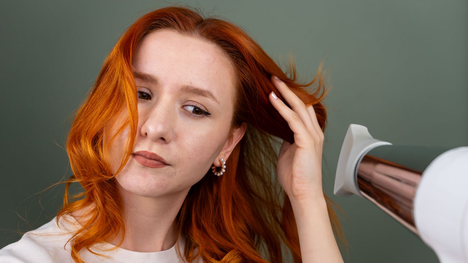 Woman blow drying fine hair upside down at the roots for volume
