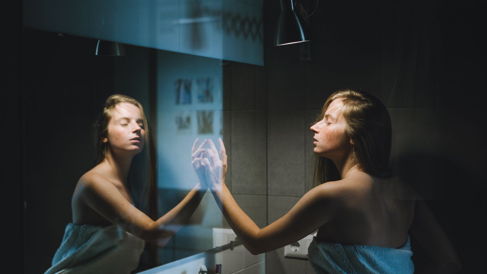 Woman with wet hair wrapped in a towel, the moment wet hair care after shower begins