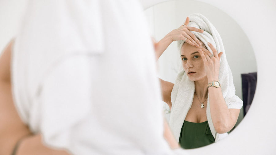 Woman with a towel on her head after washing, part of deciding how often should you wash your hair